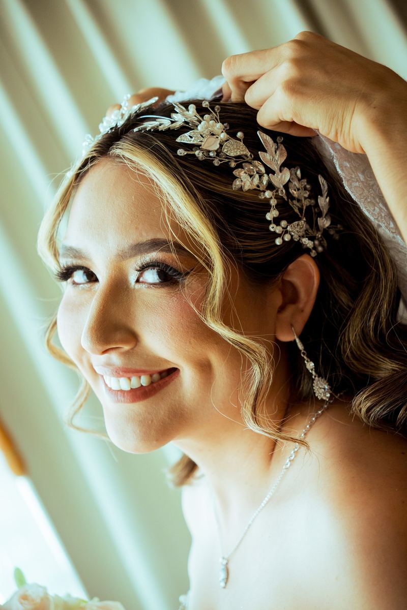 Novia sonriendo mientras le acomodan el tocado