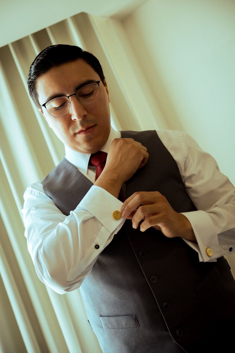 Novio poniéndose las mancuernillas con sus iniciales