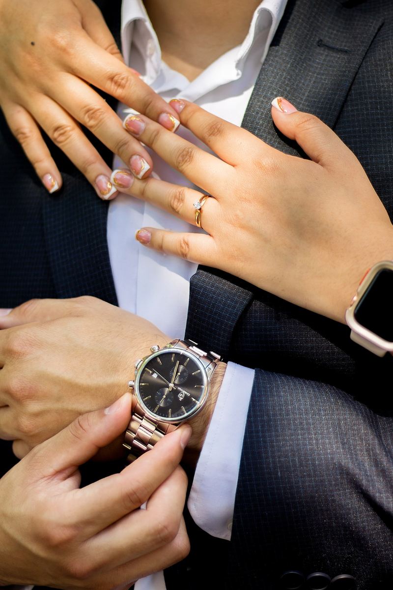 Manos de la novia con su anillo sobre el traje del novio