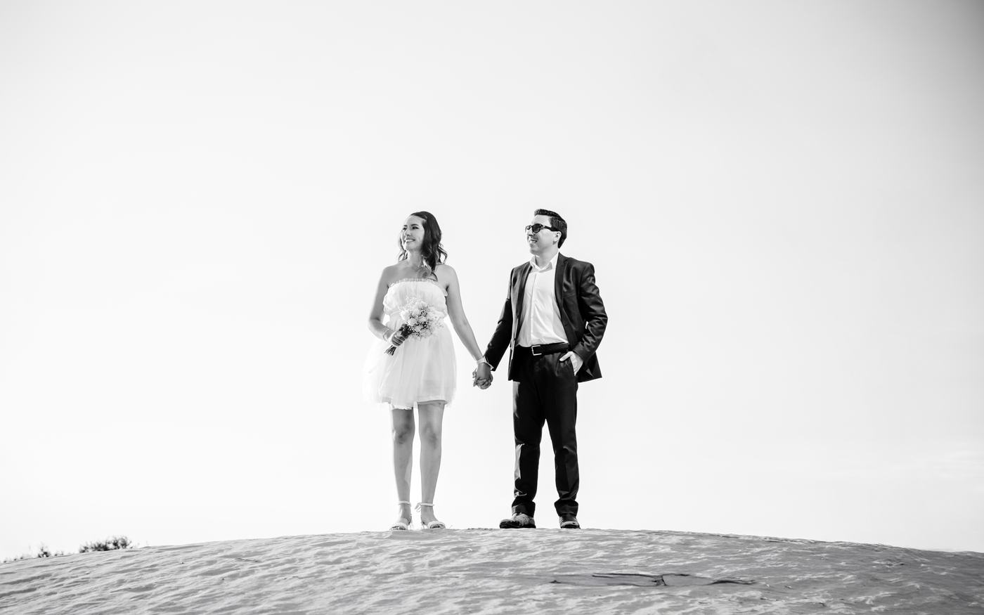 Pareja de pie sobre una duna, en blanco y negro