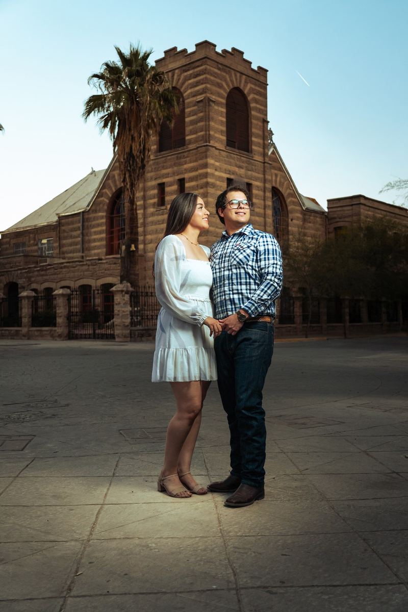 Pareja frente a un templo de piedra con una palmera
