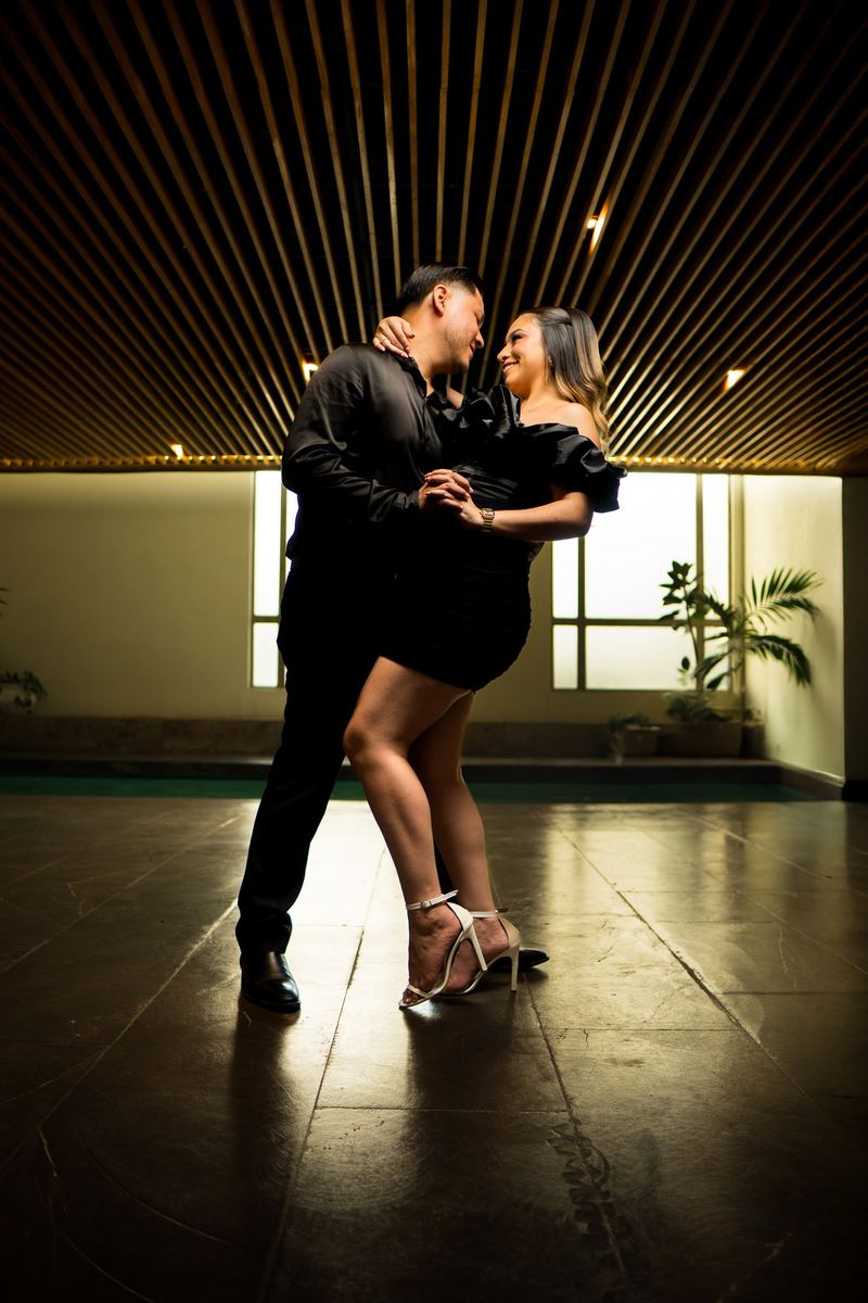 Pareja bailando en un salón con luz cálida