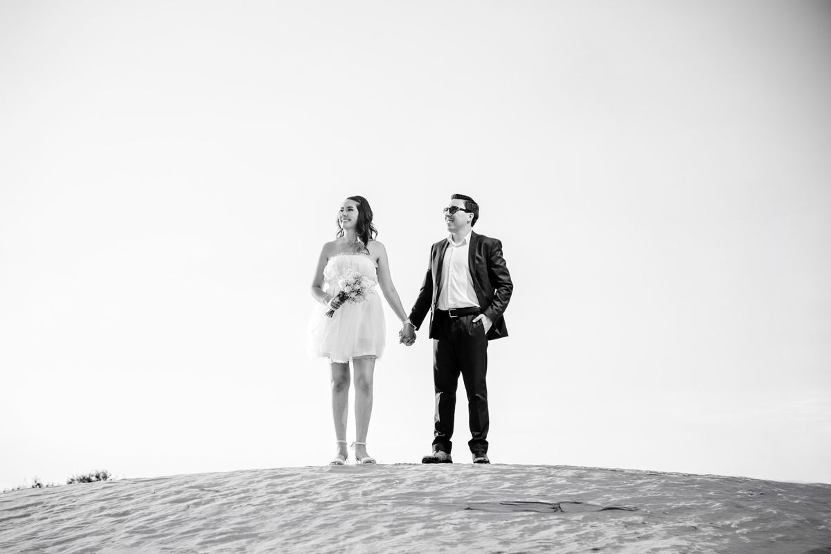 Pareja de pie sobre una duna, en blanco y negro