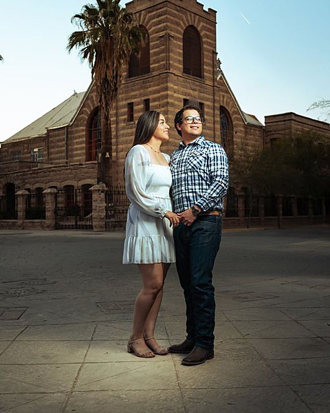 Ana y Cristian tomados de la mano frente a una iglesia de ladrillo en Torreón