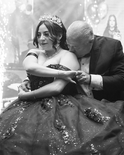 Mariam con corona y vestido de XV bailando el vals con su papá, en blanco y negro