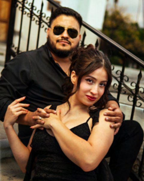 Sandra y Pepe abrazados en una escalera con barandal de hierro