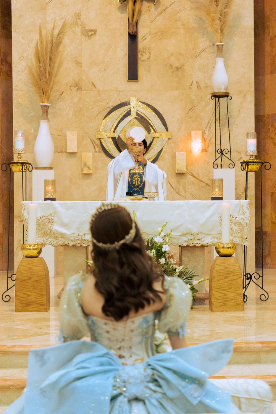Quinceañera de espaldas frente al altar durante la misa